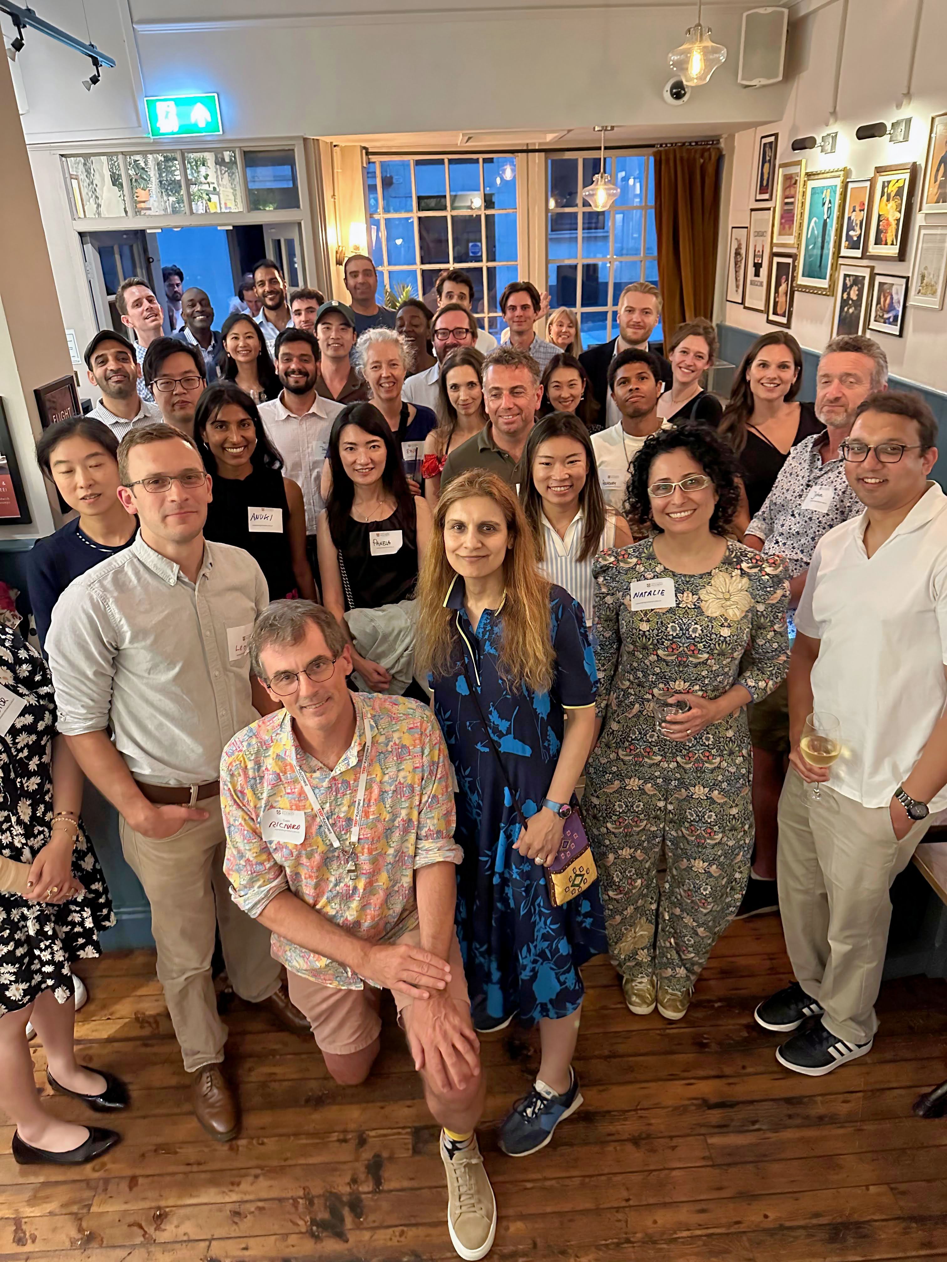 A group of alumni pose for a photo in a pub.