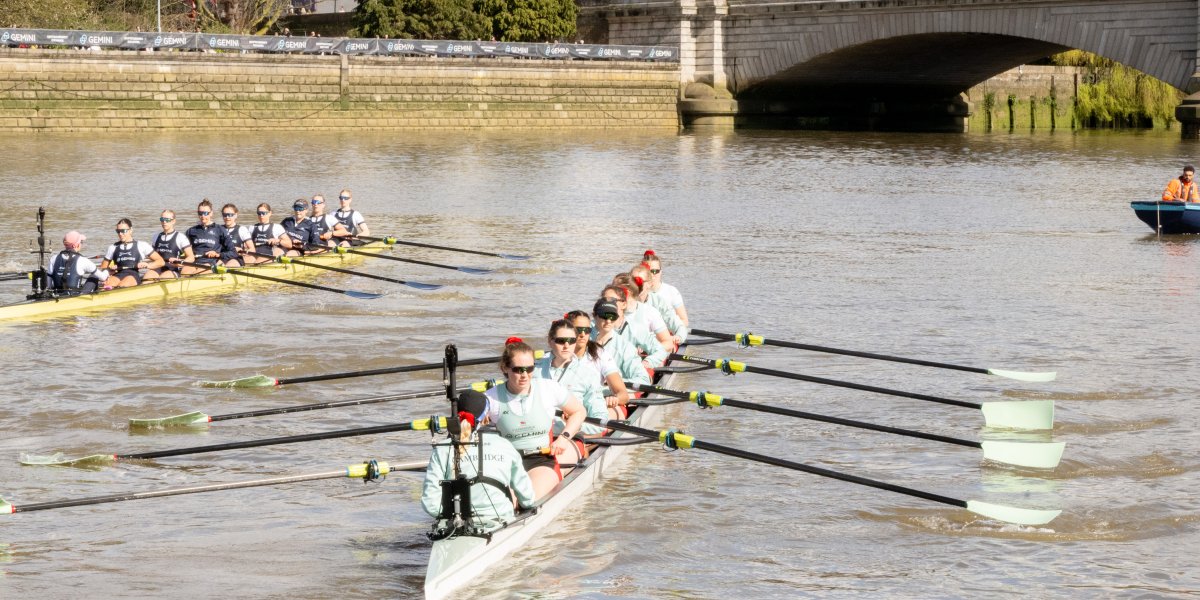 Ladies boat race teams row along the river.