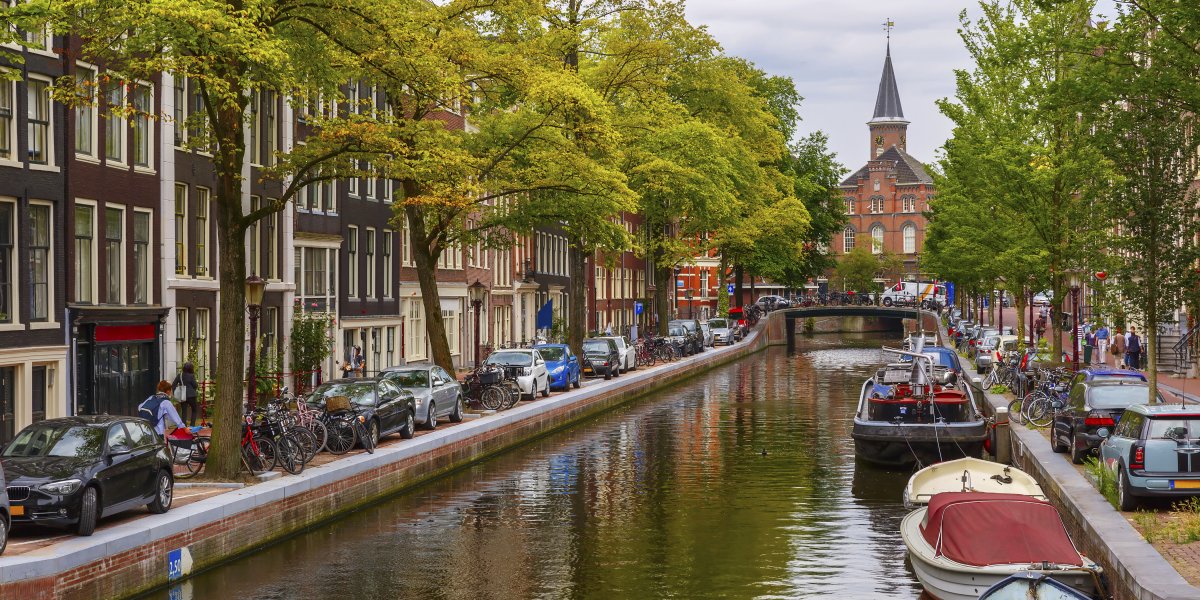 Scenic photo of a canal running through Amsterdam