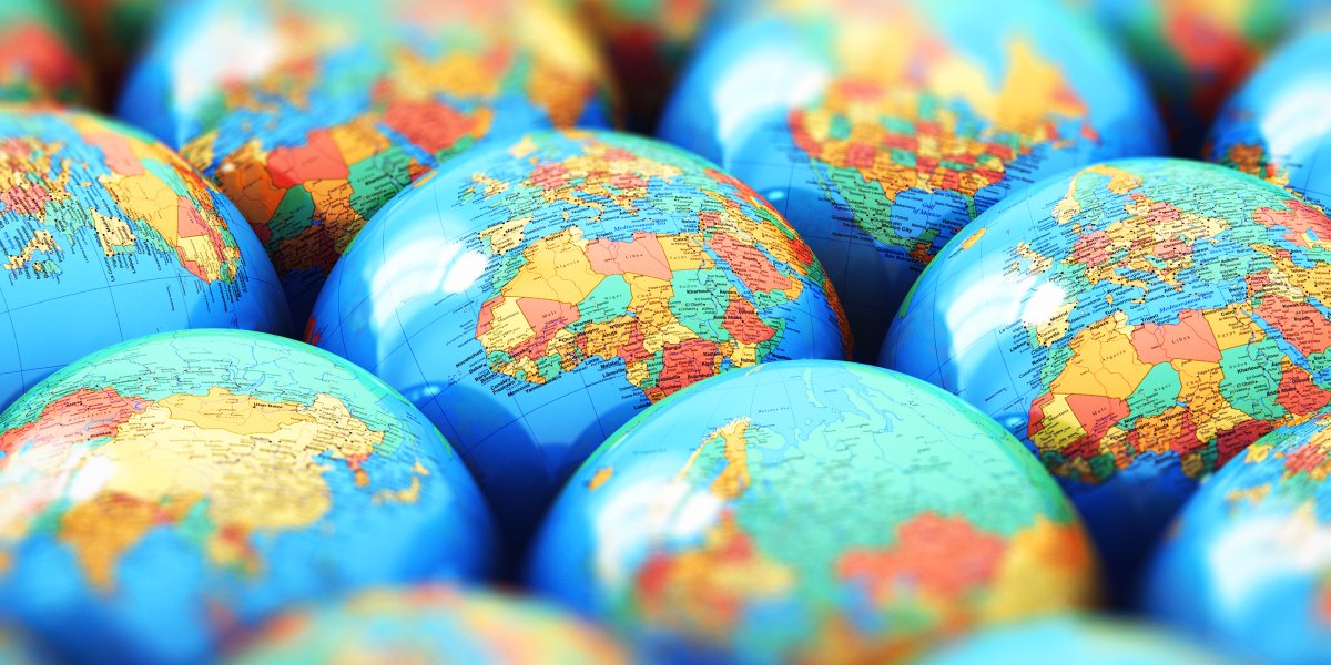 A collection of globes sit together showing different continents.