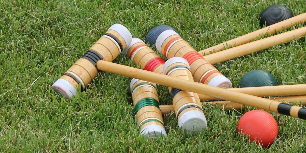 Croquet mallets and balls lying in the grass